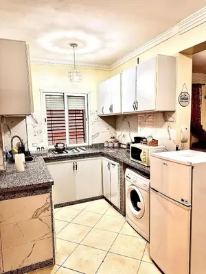a kitchen with white cabinets and a dishwasher at Maison Marocaine de Farah in Marrakech