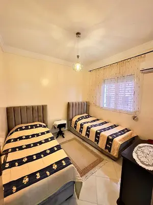 two beds in a room with a window at Maison Marocaine de Farah in Marrakech