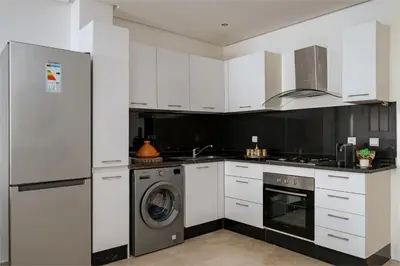 a kitchen with white cabinets and a washer and dryer at Premium stay in Guéliz-Hivernage in Marrakech