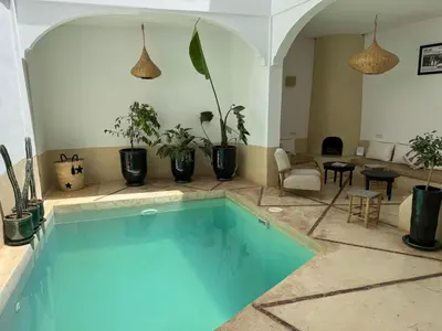a swimming pool in a room with potted plants at Riad privé Dar Sun 2 bassins & Rooftop coeur medina in Marrakech