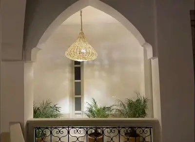a chandelier hanging over a balcony with a window at Riad privé Dar Sun 2 bassins & Rooftop coeur medina in Marrakech