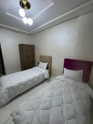 two beds sitting next to each other in a bedroom at Feels like home in Marrakech