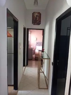 a hallway with a glass table and a bedroom at Cozy Apartment Marrakech Airport in Marrakech