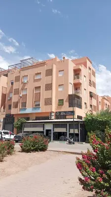 a large building with a bus parked in front of it at Cozy Apartment Marrakech Airport in Marrakech