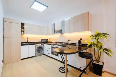 a kitchen with white cabinets and a table and a plant at Apartment in Center of Marrakech in Marrakech