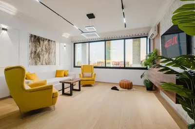 a living room with yellow chairs and a table at Apartment in Center of Marrakech in Marrakech