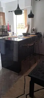 a kitchen with a black island in a room at Appartement avec piscine privée in Marrakech