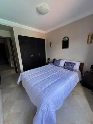 a bedroom with a large bed with blue sheets at Superbe appartement Marrakech Piscine Wifi Climatisation in Marrakech