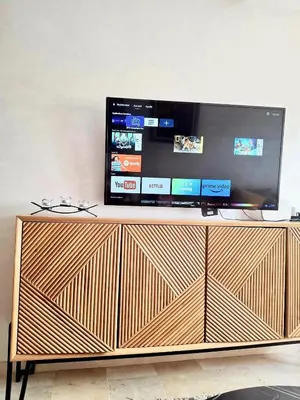 a television on top of a wooden entertainment center at Appartement a hivernage in Marrakech