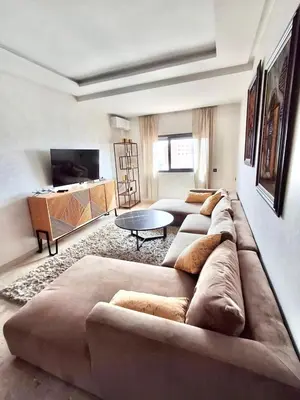a living room with a large couch and a table at Appartement a hivernage in Marrakech