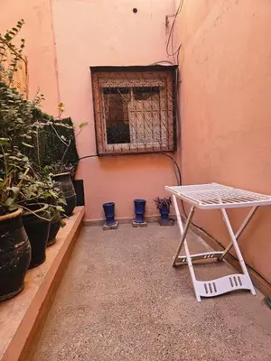 a white table in front of a window with potted plants at Residencia Salma in Marrakech