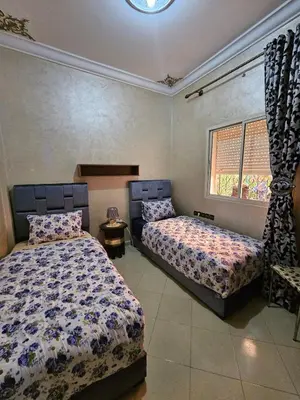 a bedroom with two beds and a window at Residencia Salma in Marrakech
