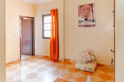 a living room with an orange curtain and a chair at Jamila home elegance hospitality fiber WiFi in Marrakech
