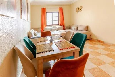 a living room with a table and chairs and a couch at Jamila home elegance hospitality fiber WiFi in Marrakech