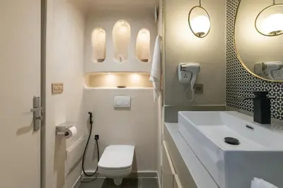 a bathroom with a sink and a toilet and a mirror at Boho Nest Gueliz Center, Terrace & Quiet in Marrakech