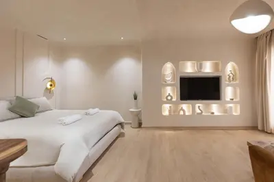 a white bedroom with a bed and a tv at Boho Nest Gueliz Center, Terrace & Quiet in Marrakech