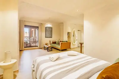 a bedroom with a large bed and a living room at Boho Nest Gueliz Center, Terrace & Quiet in Marrakech