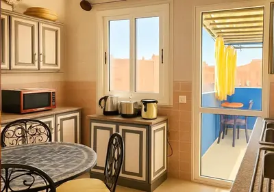 a small kitchen with a table and a window at Appart AMITAF in Marrakech