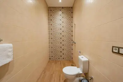 a small bathroom with a toilet and a shower at Villa Izia - Quiet, nature and private pool in Marrakech