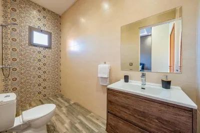 a bathroom with a sink and a toilet and a mirror at Villa Izia - Quiet, nature and private pool in Marrakech