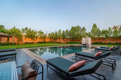a pool with chaise lounge chairs and a swimming pool at Villa Izia - Quiet, nature and private pool in Marrakech