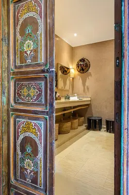 a bathroom with a sink and a wooden door at Dar Toozween in Marrakech