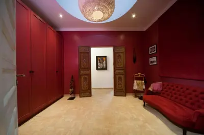 a living room with red walls and a red couch at Dar Toozween in Marrakech