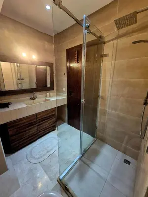 a bathroom with a shower and a sink at Comfortable poolside apartment near city center in Marrakech