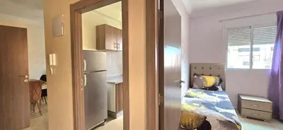 a small bedroom with a bed and a refrigerator at Nice apart well located 2 Rooms -Only Family in Marrakech