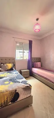 a bedroom with two beds and a chandelier at Nice apart well located 2 Rooms -Only Family in Marrakech