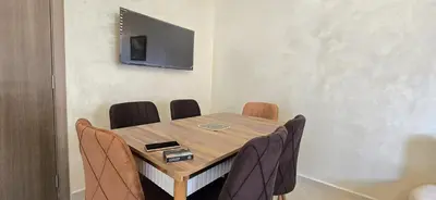 a dining room table with chairs and a television on the wall at Nice apart well located 2 Rooms -Only Family in Marrakech