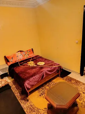 a bedroom with a bed with a red comforter at Marrakech mhamid in Marrakech