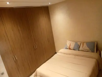 a small bedroom with a bed and wooden cabinets at Chambre unique in Marrakech