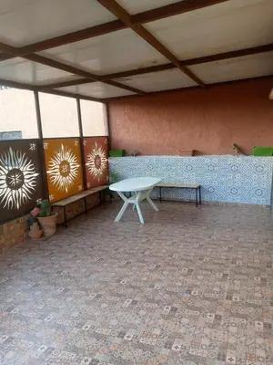 a patio with a white table and a bench at Chambre unique in Marrakech
