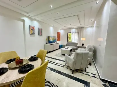 a living room with a table and chairs and a couch at Elegant Suit in Guéliz in Marrakech