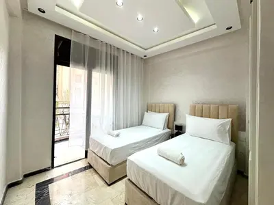 two beds in a room with a window at Elegant Suit in Guéliz in Marrakech
