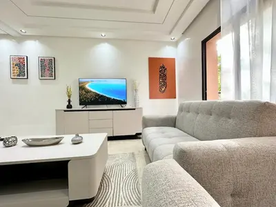 a living room with a couch and a tv at Elegant Suit in Guéliz in Marrakech