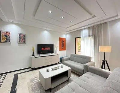 a living room with a couch and a tv at Elegant Suit in Guéliz in Marrakech