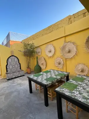 a wall with two tables in front of a wall at Khamsa in Marrakech