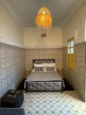 a bedroom with a bed and a chandelier at Khamsa in Marrakech