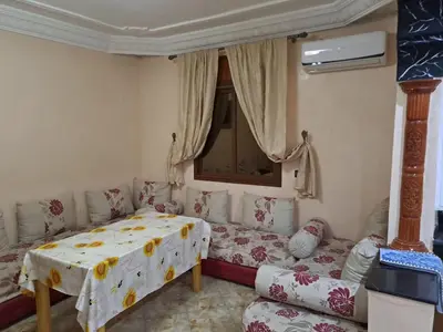 a bedroom with a bed and a couch and a window at Nour's PLACE in Marrakech