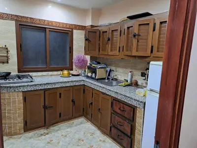 a kitchen with wooden cabinets and a sink at Nour's PLACE in Marrakech