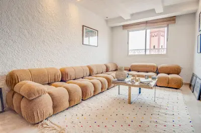 a living room with a large couch and a table at Stylish 2BR With Balcony & Designer Touches in Gueliz in Marrakech