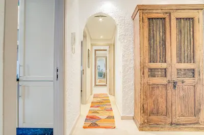 a hallway with a wooden door and a rug at Stylish 2BR With Balcony & Designer Touches in Gueliz in Marrakech