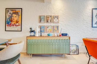 a living room with a green cabinet and pictures on the wall at Stylish 2BR With Balcony & Designer Touches in Gueliz in Marrakech