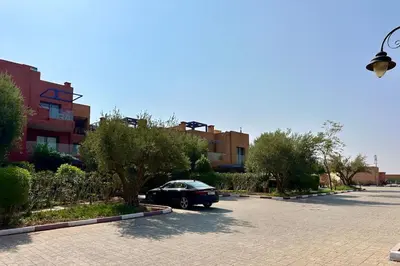 a black car parked in a parking lot at Sunny apartment with rooftop Water Park included in Dar Caïd Layadi