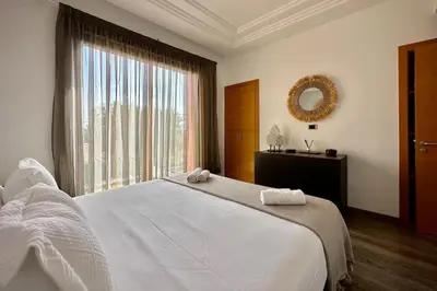 a bedroom with a large white bed and a window at Sunny apartment with rooftop Water Park included in Dar Caïd Layadi