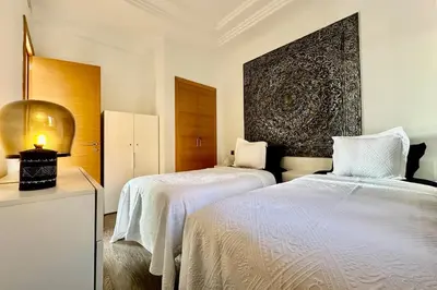 a bedroom with two beds and a large wall at Sunny apartment with rooftop Water Park included in Dar Caïd Layadi