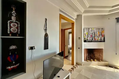a living room with a television and a fireplace at Sunny apartment with rooftop Water Park included in Dar Caïd Layadi