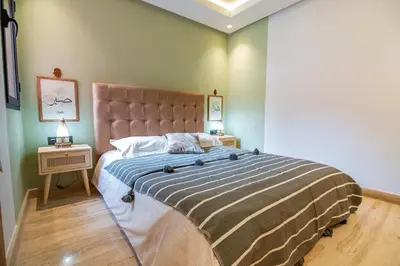 a bedroom with a large bed and a night stand at Marrakech Oasis, Central and Modern in Marrakech